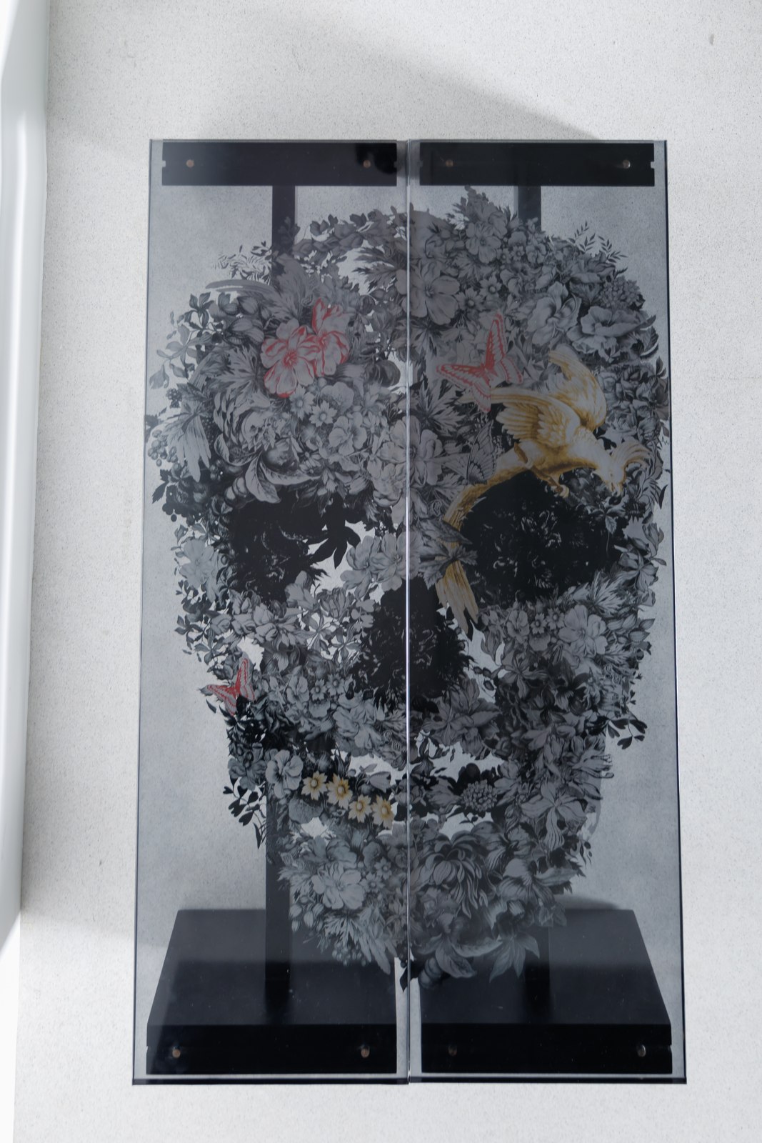 Overhead view: two separate art benches placed side by side, their imagery combining to form a complete floral skull.