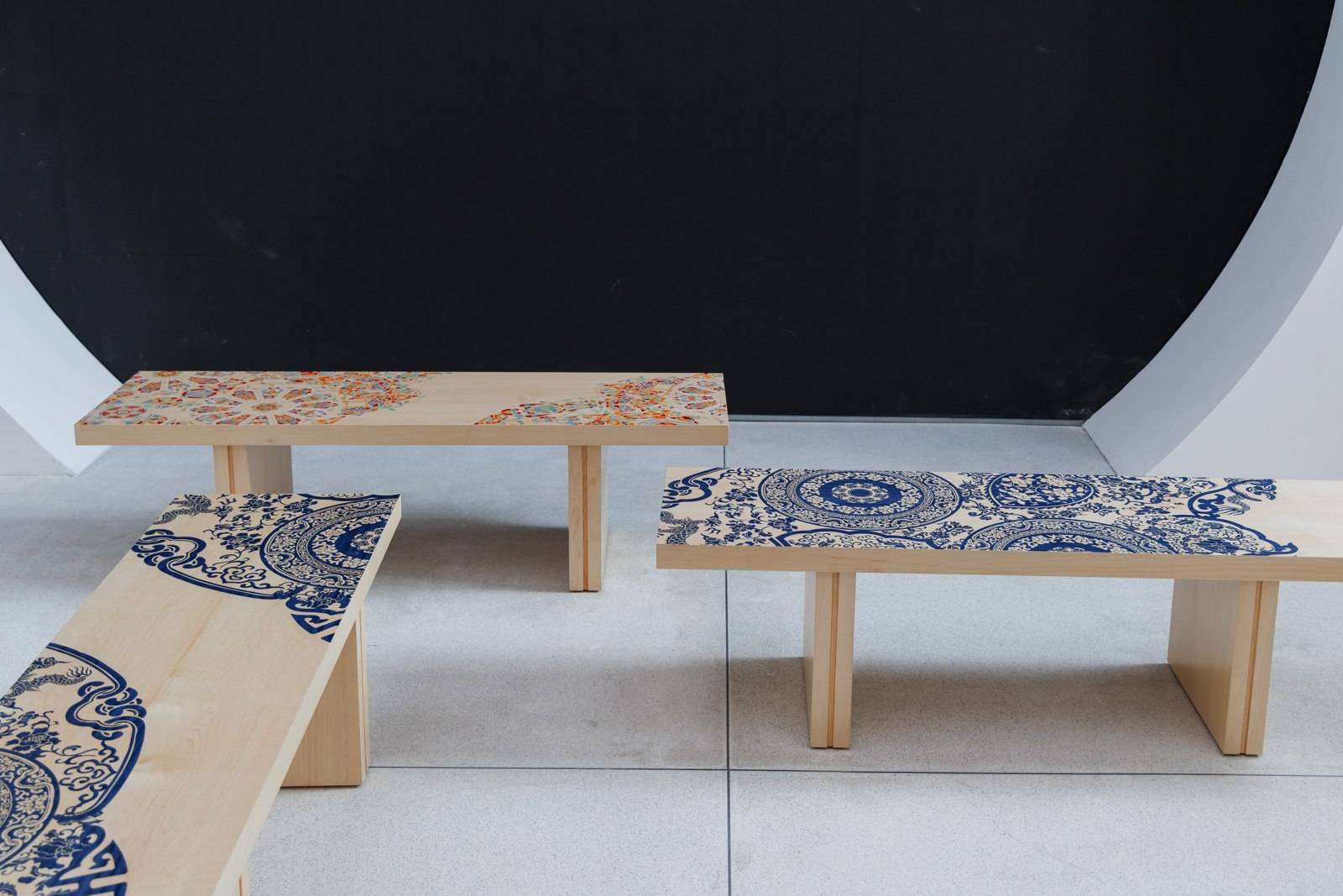 Blue-and-white art benches arranged around a circular work in the gallery.